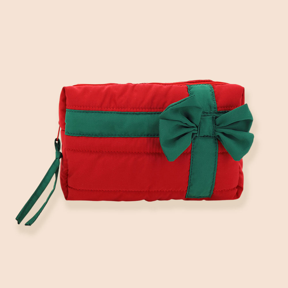 A vibrant red quilted cosmetic pouch bag features a green bow and stripe accent, giving it a festive holiday appearance. The bag is designed with a secure zip closure, ensuring that beauty essentials are organized and easily accessible.