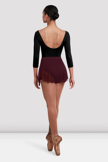 A dancer is seen from the back, wearing a black leotard with long sleeves and a deep neckline, paired with a maroon Ladies Jaye Mesh Skirt.