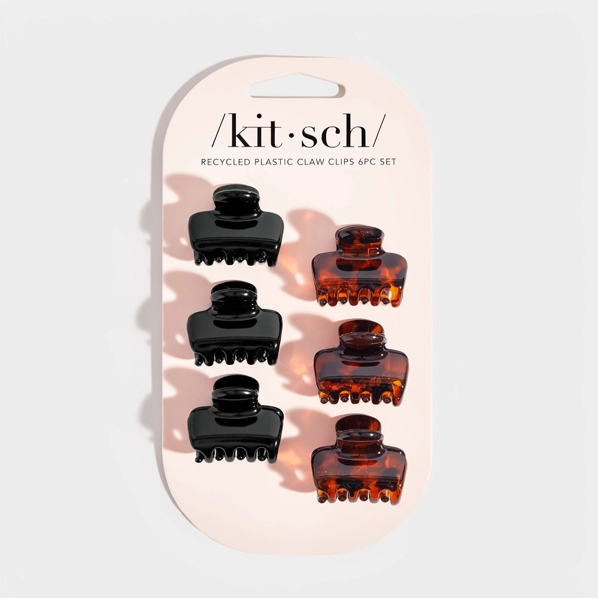 A pack of six mini claw clips from the brand Kitsch is displayed on a light background. The set includes three black clips and three tortoise clips, featuring a glossy finish and a cloud design, ideal for styling bangs and shorter.