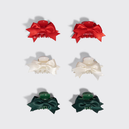 A set of six mini claw clips from the brands holiday collection is displayed against a light gray background.