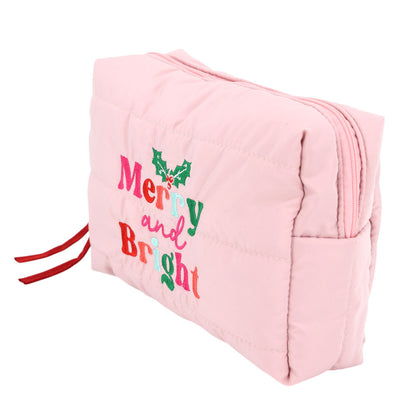 A pink quilted cosmetic pouch bag features festive embroidered lettering that reads Merry and Bright, adorned with green holly leaves.