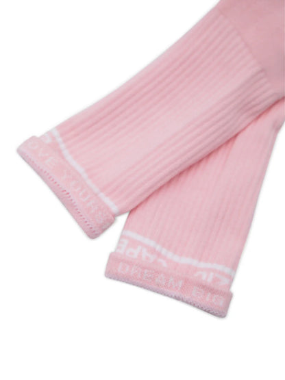 Two unisex Varsity Crew Socks in a soft pink color are displayed, featuring a ribbed texture and a white Capezio logo at the top. The socks are laid flat side by side, showcasing their vintage style and comfortable design.
