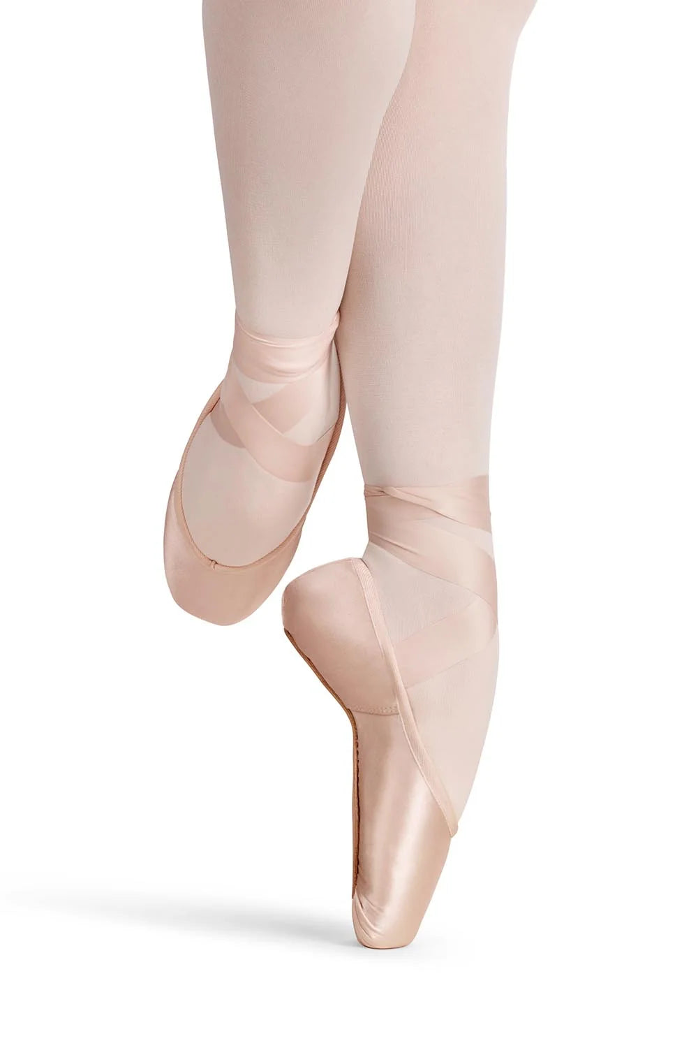 A ballerina is gracefully posed en pointe, wearing the Akoya Flexible Soft Shank Pointe Shoe in a soft pink color.