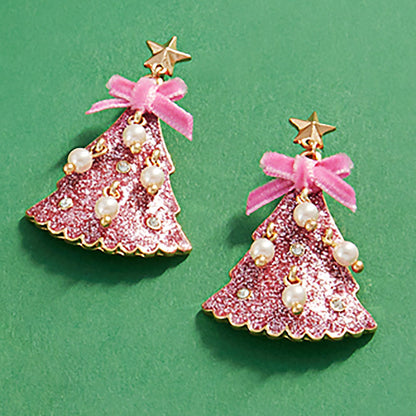 These glittered enamel holiday tree dangle earrings feature a vibrant pink color with a shimmering finish.