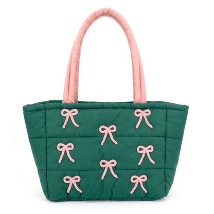 This image features a green quilted tote bag adorned with pink bow embroidery accents. The bag has two sturdy pink handles and a spacious design, ideal for everyday use and organization.