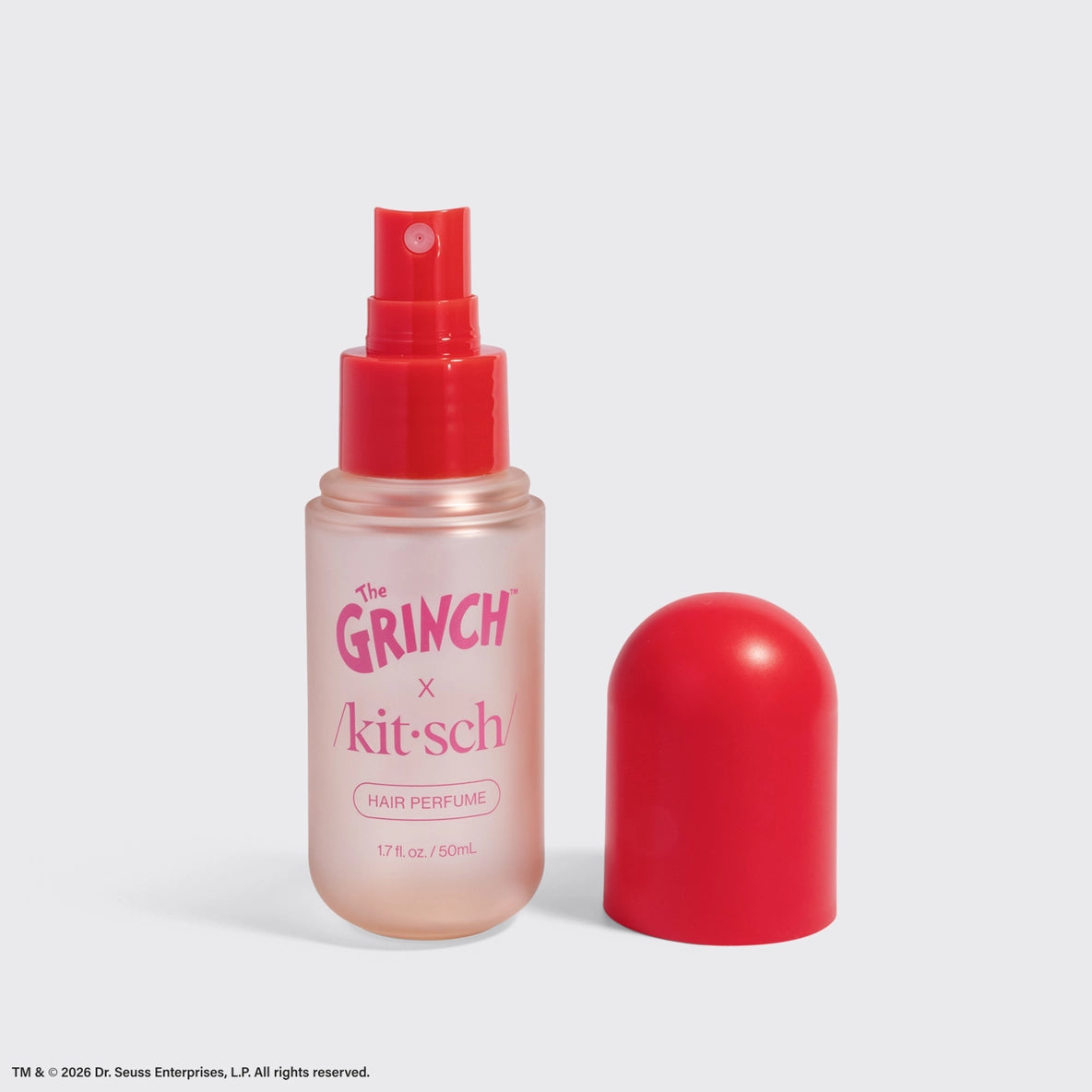 The image features a bottle of The Grinch x Kitsch Cherry Cheer Hair Perfume, showcasing a clear container with a pinkish hue.
