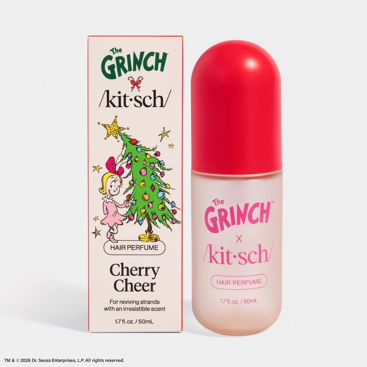 The image features The Grinch x Kitsch Cherry Cheer Hair Perfume, presented in a clear bottle with a vibrant red cap, set against a white background.
