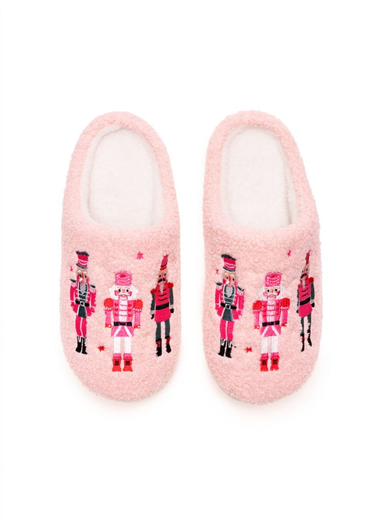 The image features a pair of Living Royal Adult Nutcracker Slippers in soft pink, showcasing a cozy, fuzzy texture.
