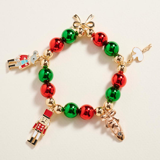 A festive Nutcracker Bow Charm Beaded Stretch Bracelet features alternating red and green beads, accented with gold elements.