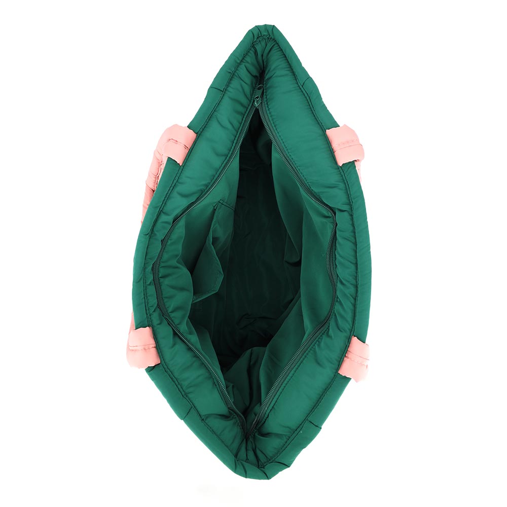 An overhead view of a green quilted tote bag with pink bow accents. The spacious interior is visible, showcasing its roomy design and interior structure, including a zipper closure at the top.
