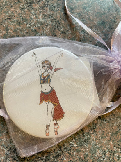 A Nutcracker-themed pocket mirror featuring a colorful illustration of a dancer in a vibrant costume, showcasing a joyful pose with arms raised.