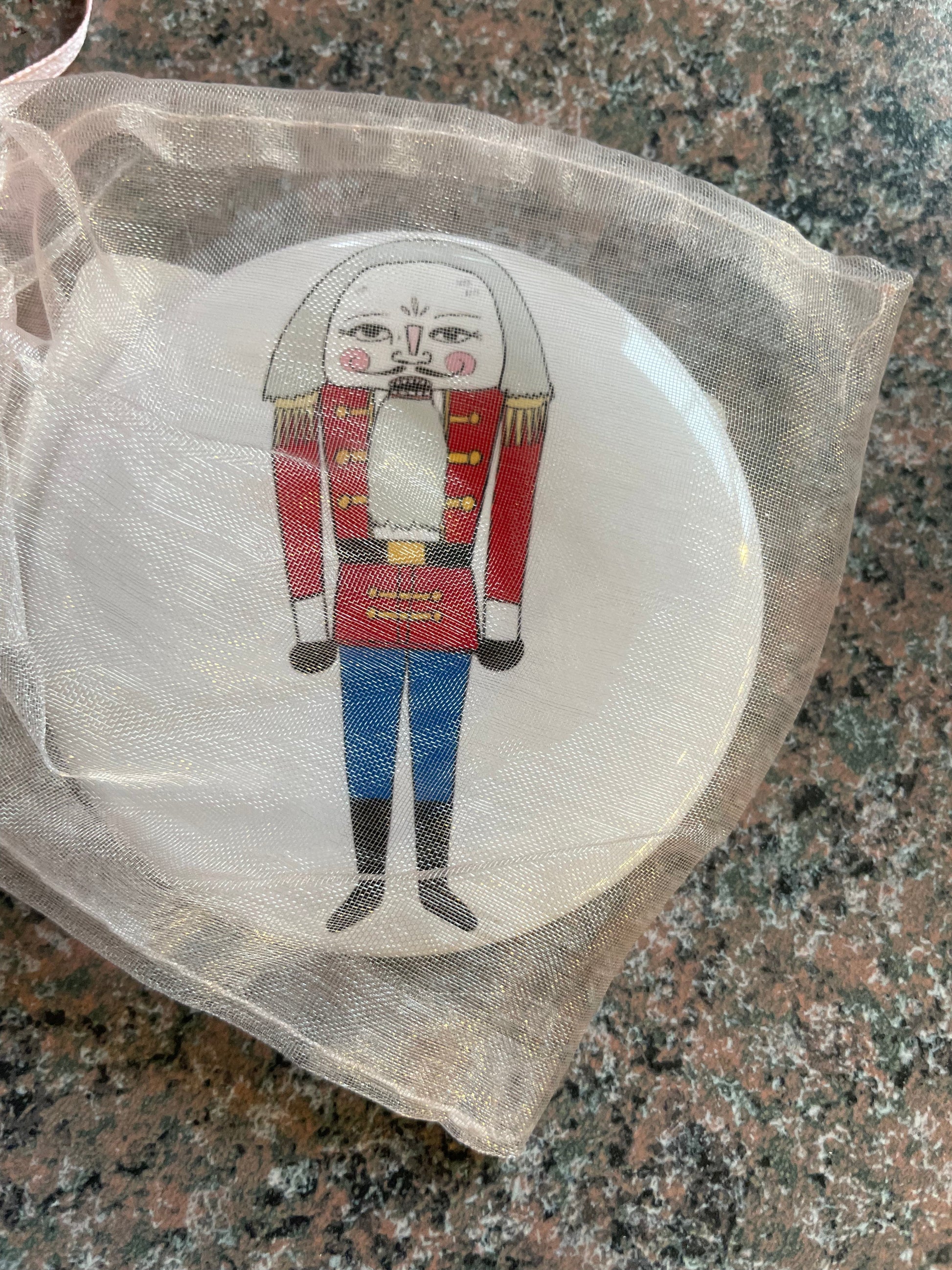 A Nutcracker-themed pocket mirror is displayed, featuring a cheerful Nutcracker soldier with a red uniform, blue trousers, and a white beard.